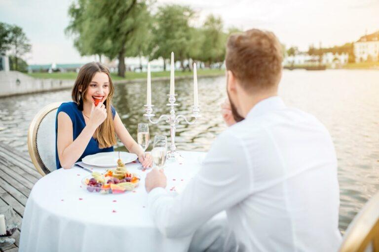 Couple Eating Lunch Near Water at a Table